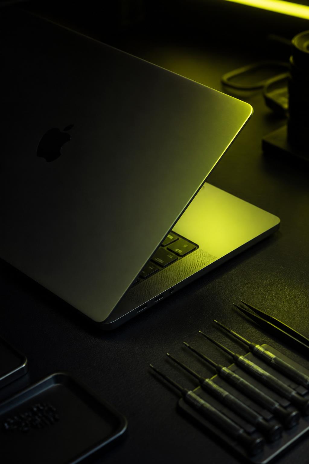 MacBook ouvert sur établi pour réparation à Liège
